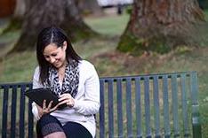 lady reading on a bench in the quad